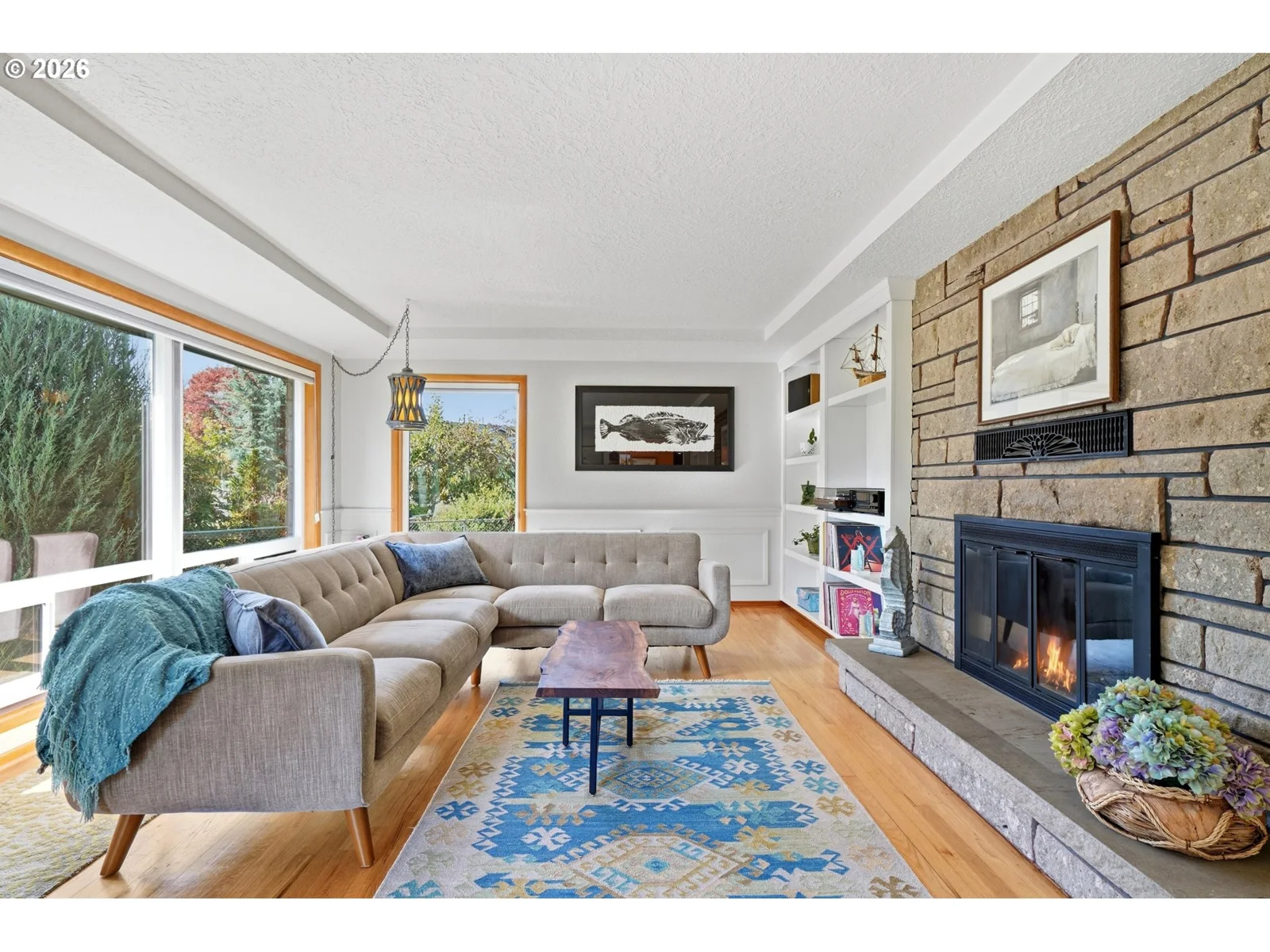 Living room with stone fireplace and hardwood floors